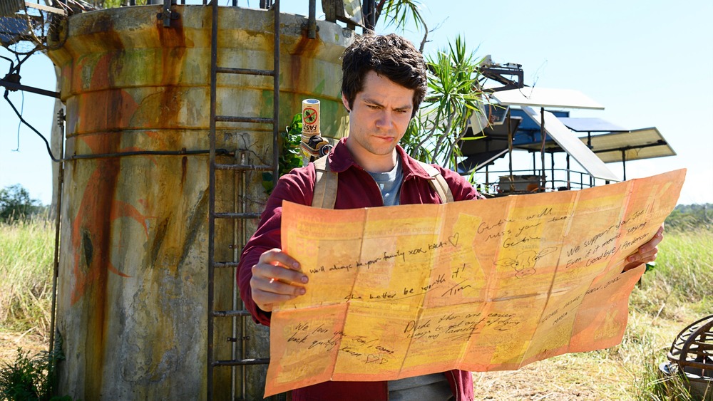 Dylan O'Brien holding map in Love and Monsters