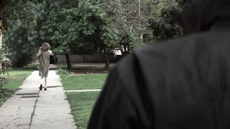 The Shape's back in foreground, Laurie walks ahead