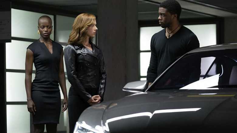 Ayo, Black Widow, and T'Challa talk next to a car