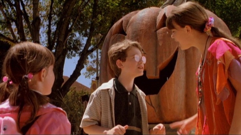 The three Piper siblings discuss in front of a giant pumpkin