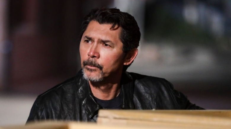 Lou Diamond Phillips standing in front of stacked boxes