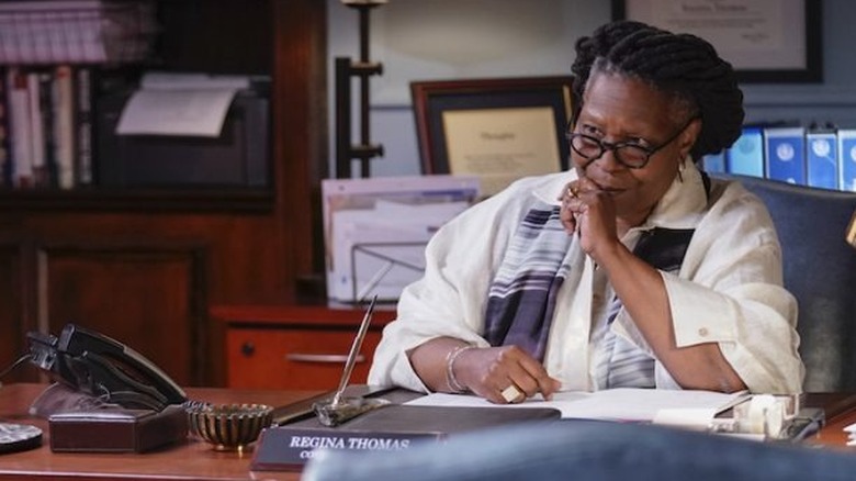 Whoopi Goldberg sitting at a desk