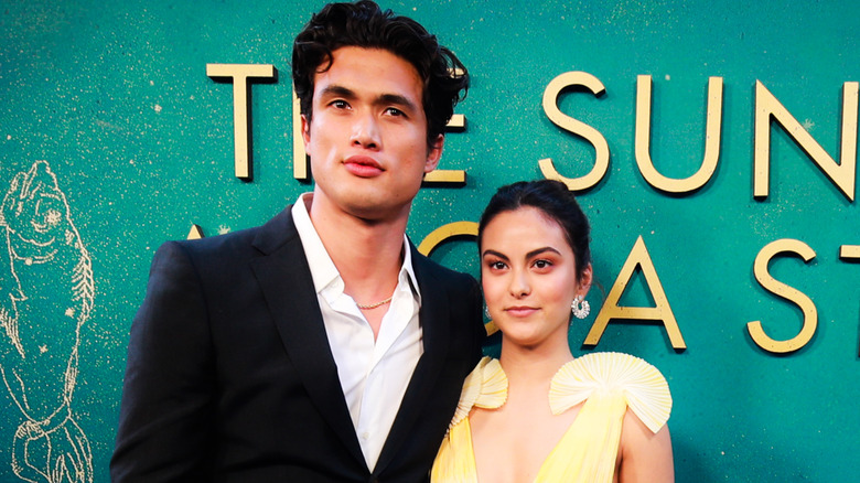Camila Mendes and Charles Melton stand close