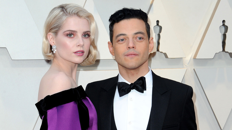 Lucy Boynton and Rami Malek stand together