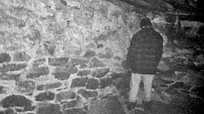 man in the corner of a basement