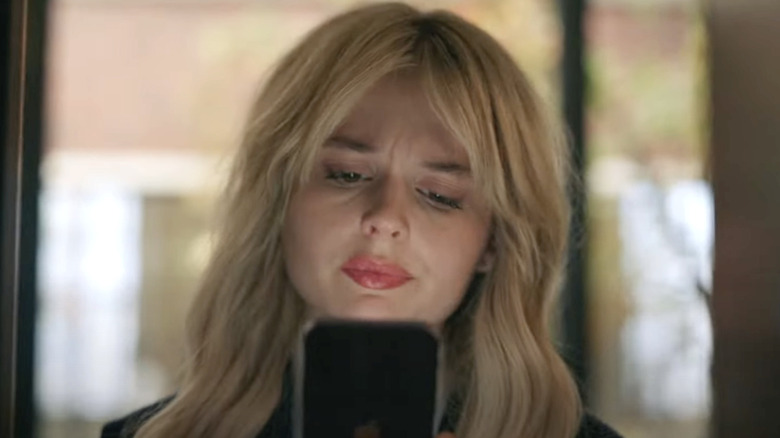 Emily Alyn Lind looks at phone