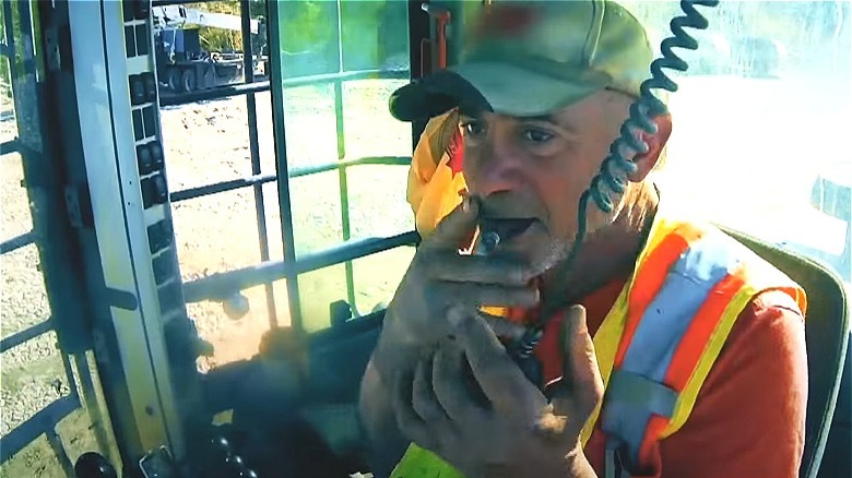 Chris Doumitt smoking while handling some heavy equipment 