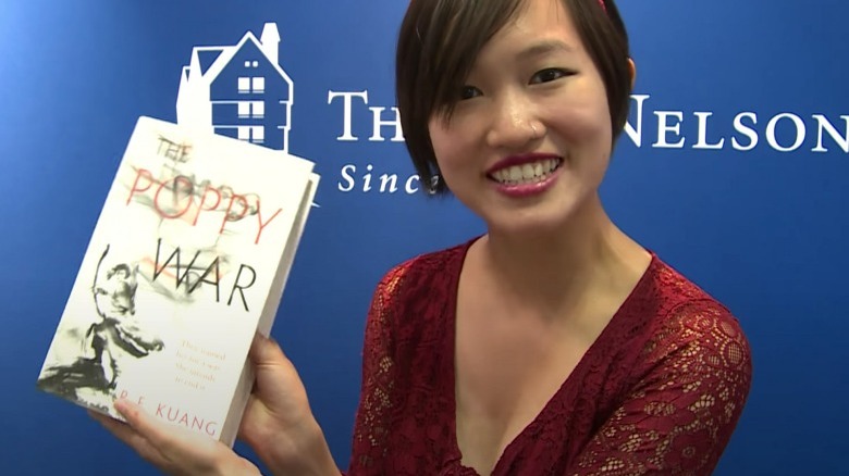 Rebecca Kuang's posing with book