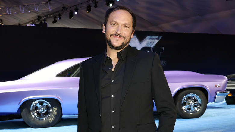 Louis Leterrier poses in front of car