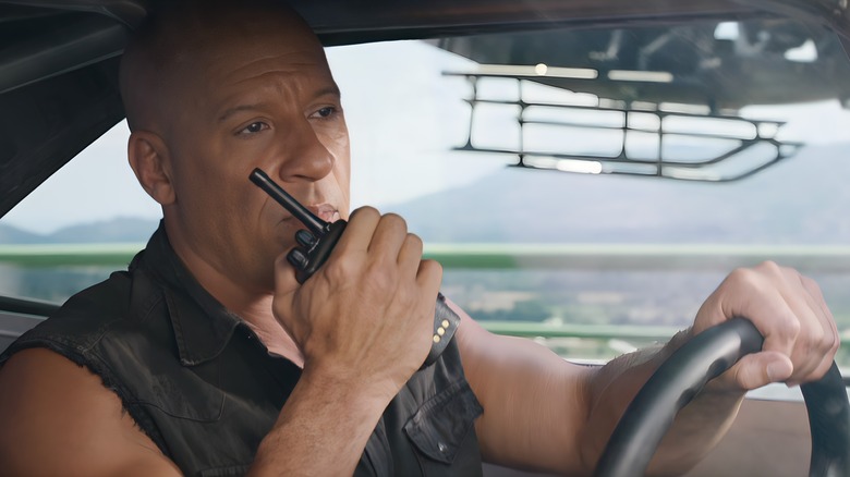 Dominic Toretto holding walkie talkie and driving