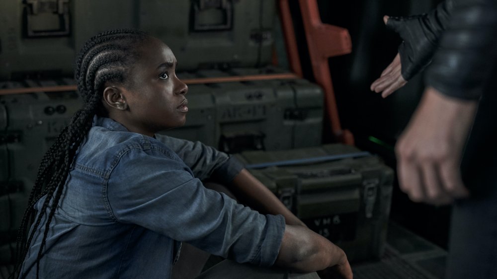 Andy (Charlize Theron) offers her hand to Nile (KiKi Layne) in The Old Guard