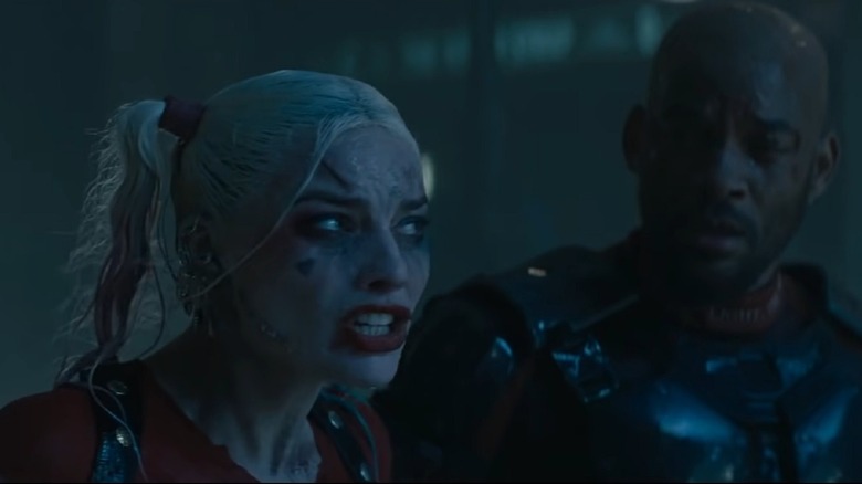 Deadshot looking at an emotional Harley Quinn