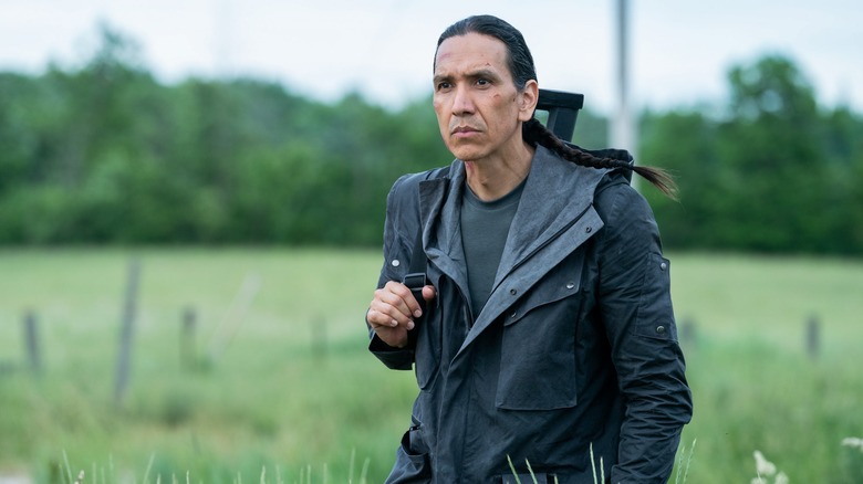 John Rainbird walking through a field