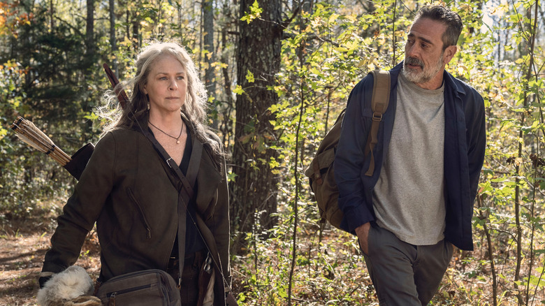 Carol and Negan walking in woods