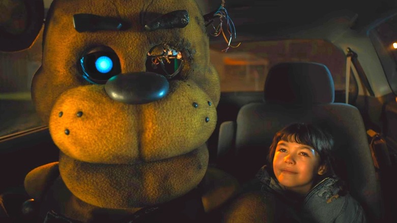 Freddy bear next to kid in car