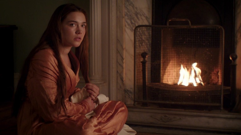 Kathering sitting by a fireplace