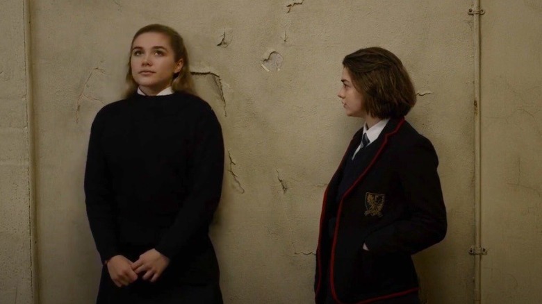 Abbie and Lydia lean against wall 