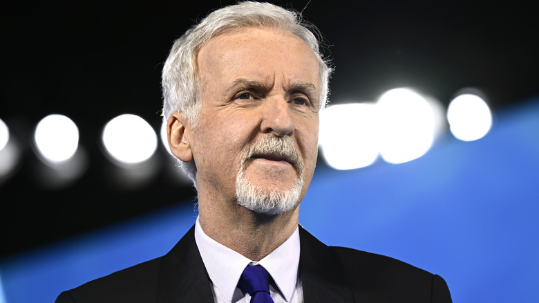 James Cameron black suit blue tie