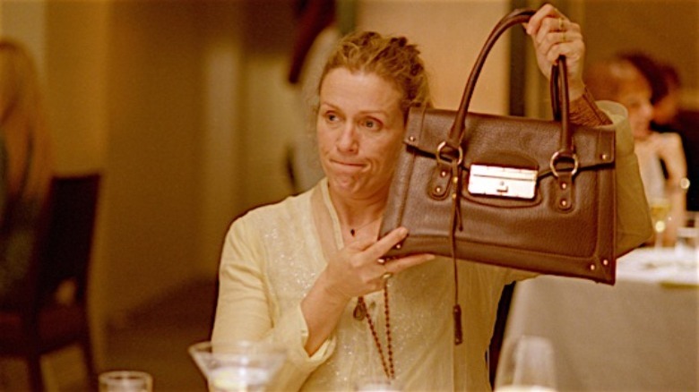 Frances McDormand holding up a purse