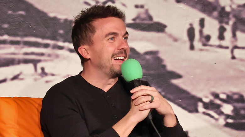 Frankie Muniz holding microphone smiling