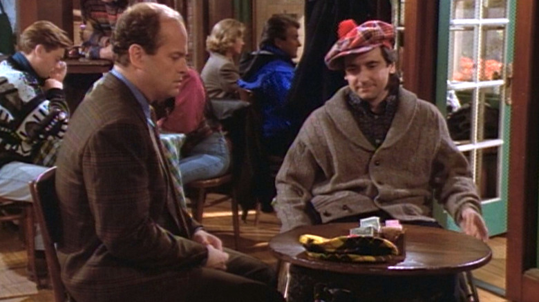 Frasier holding a hat next to Bob