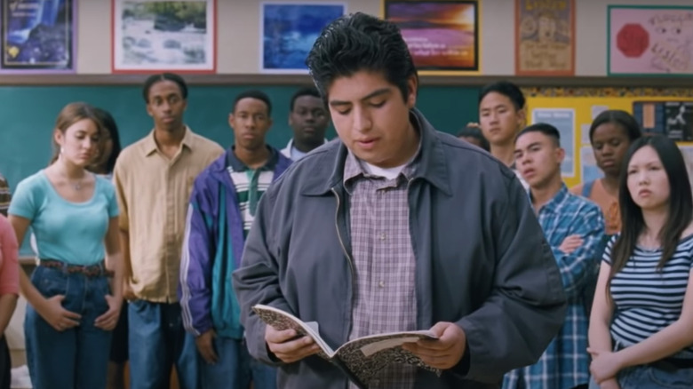 Student reading from notebook in front of other students