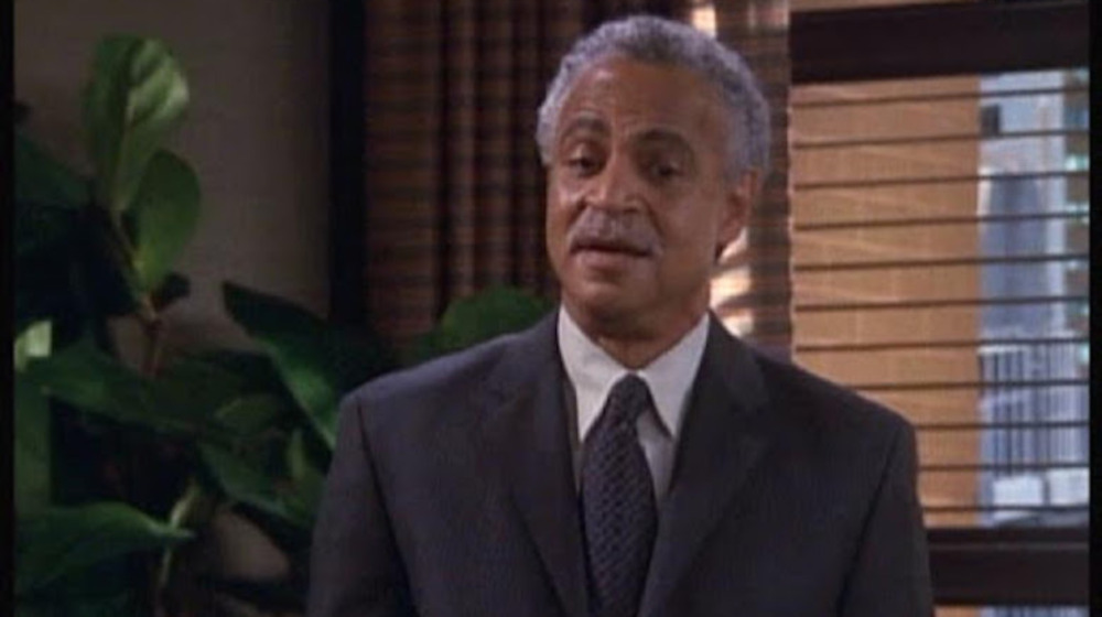 Russell stands in a suit on "Friends"