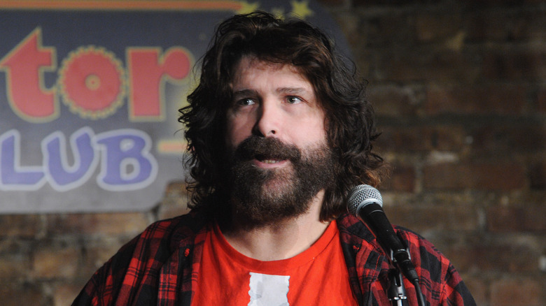 Mick Foley talking to the side with a microphone