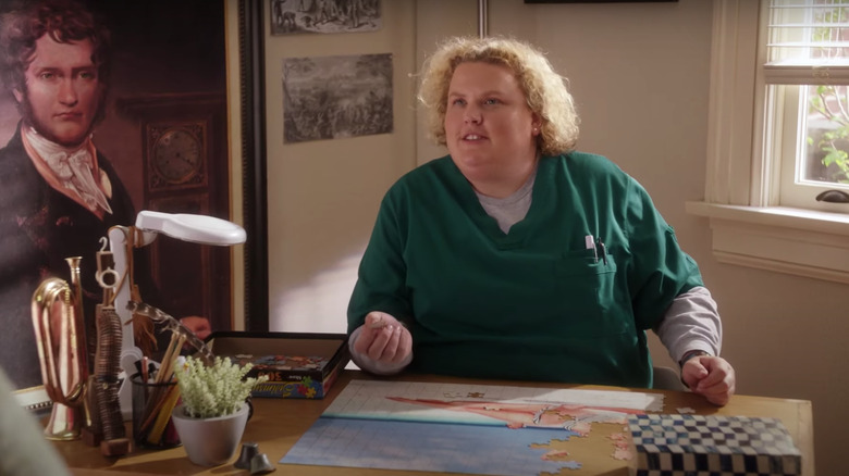 Colette sitting behind a desk in scrubs