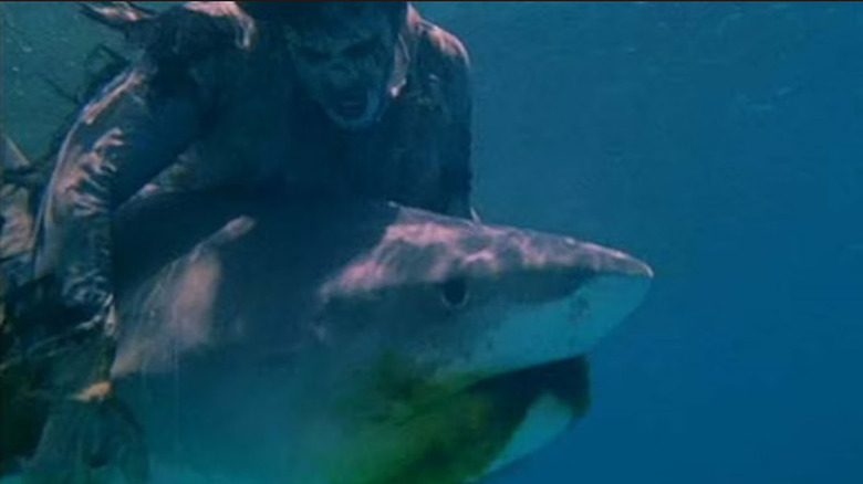 A zombie fighting a shark underwater