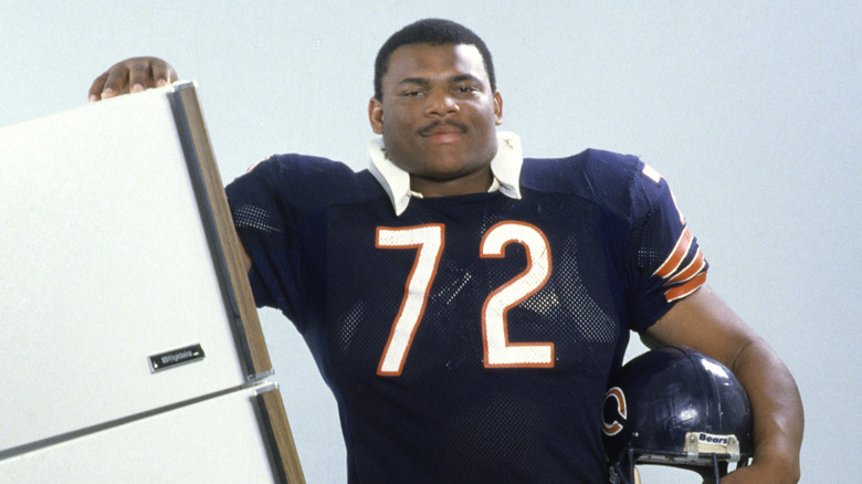 William Perry poses next to refrigerator