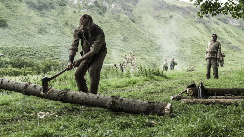 The Hound chopping wood Ray behind him