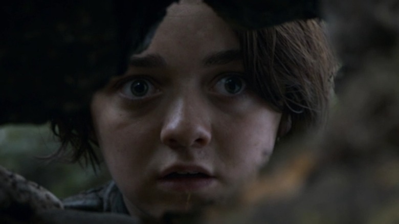 Arya hiding behind a tree