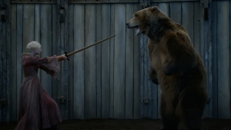 Brienne holding her sword towards a bear