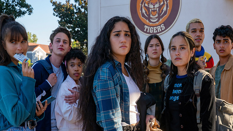 The main cast posing in front of the school