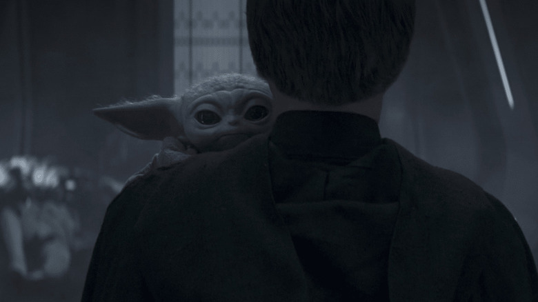 Grogu being carried by Luke