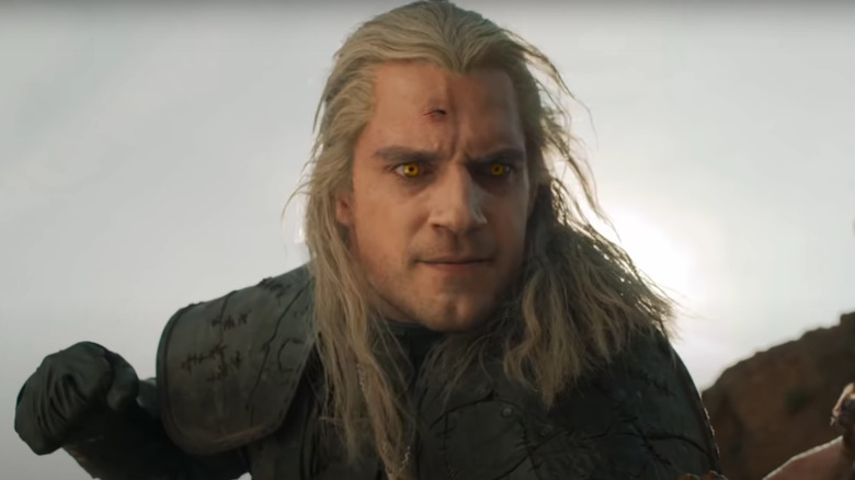 Geralt looking menacing, pulling back to punch someone