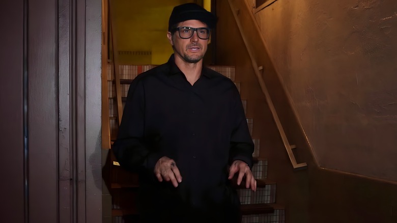 Zak Bagans talking with hands in front of brown steps