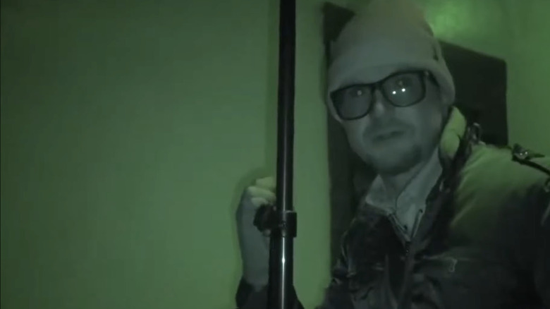 Zak Bagans wanders through a dark location. 