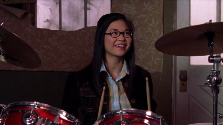 Keiko Agena smiling and playing the drums