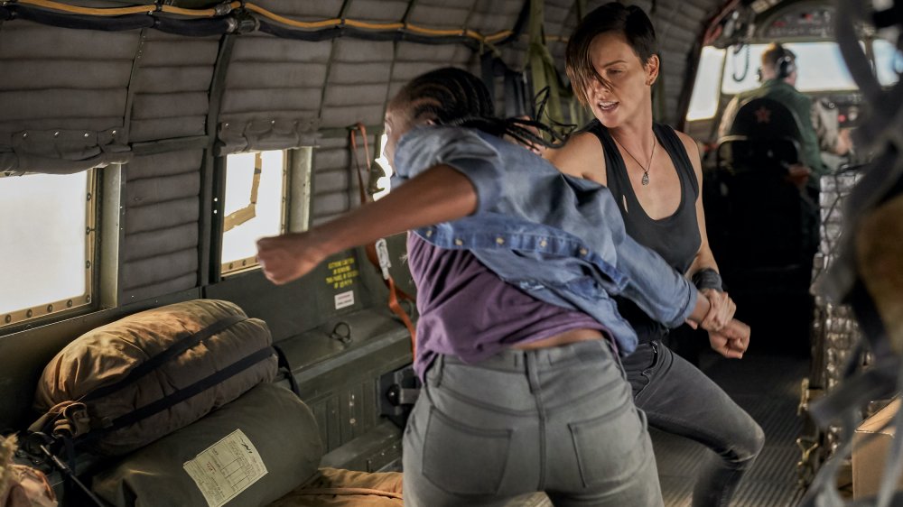 Kiki Layne (Nile), Charlize Theron (Andy) fight on an airplane in The Old Guard. 