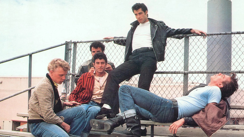 Five young men sit lazily on bleachers