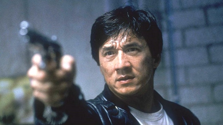 Jackie Chan pointing a pistol