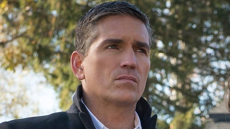 John Reese looks on with a stoic expression.