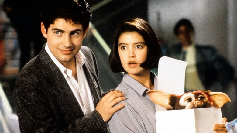 Zach Galligan and Phoebe Cates holding Gizmo Gremlins 2