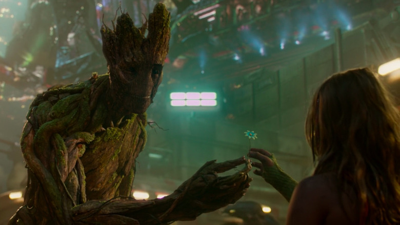 Groot hands a little girl a flower