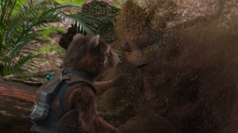 Groot turns to ash while Rocket tries to touch him