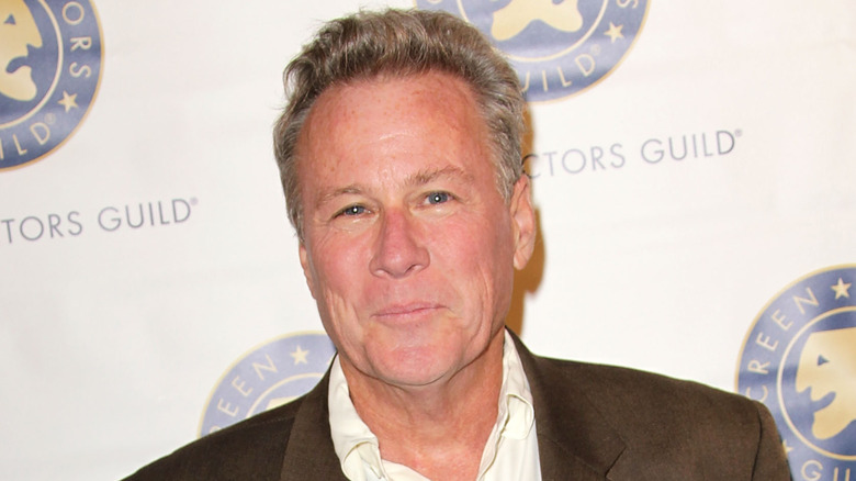 John Heard gives a tight-lipped smile