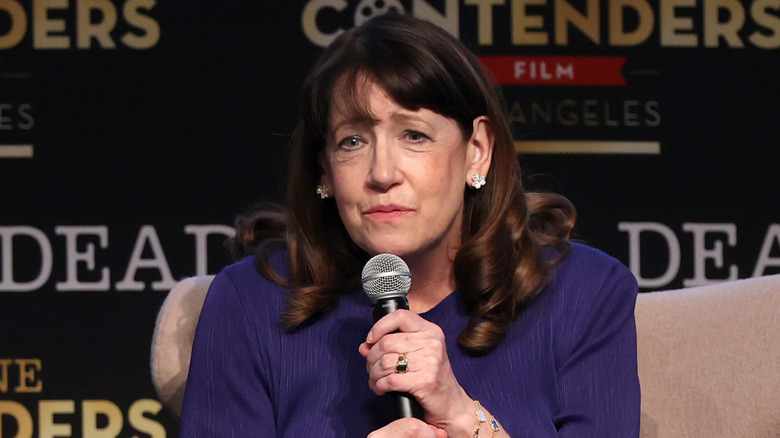 Ann Dowd listens while holding a microphone