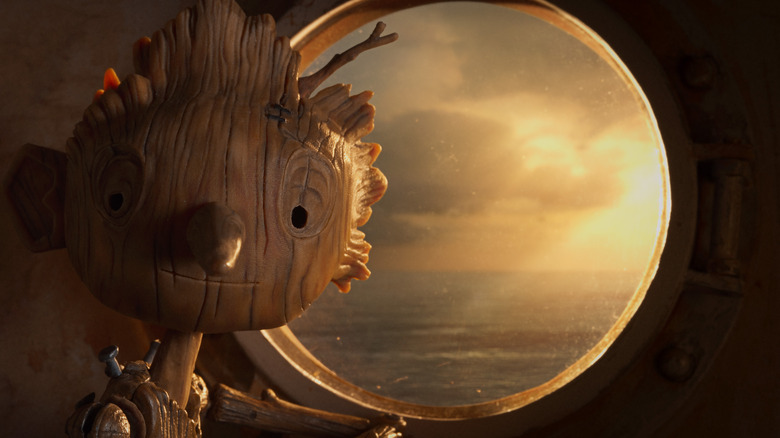 Pinocchio sitting by a window in Guillermo del Toro's Pinocchio